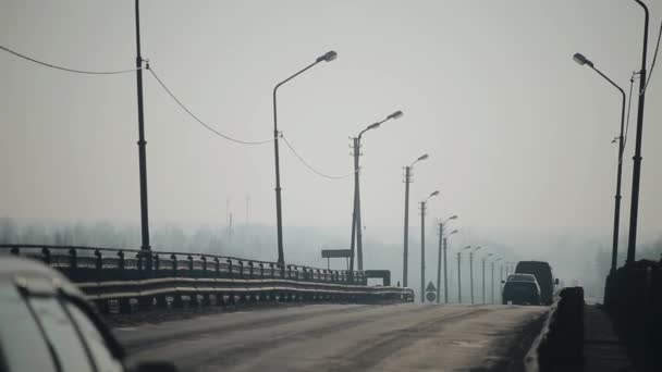 Les voitures passent sur le pont. Matin et brouillard. Silhouettes de voiture — Video