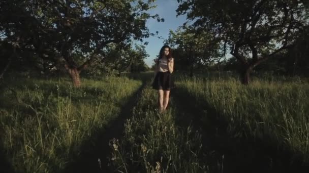 Breed uitzicht op mooie brunette meisje p in de zomer elegante kleren tegen een groene bomen. Gelukkig elegant meisje in bos. — Stockvideo
