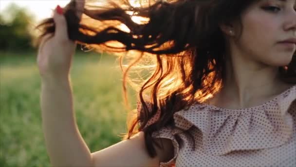 Mooi meisje neemt haar haar op zonsondergang achtergrond. Tiener meisje poseren op de natuur. Mooi buiten model. — Stockvideo