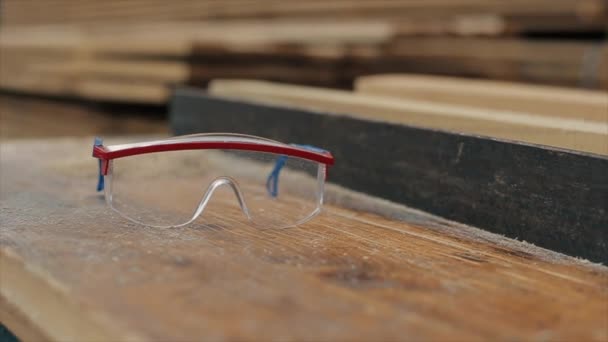 Gafas de construcción. aserrín alrededor. Un aserradero. Concepto de cosecha de madera. Movimiento lento . — Vídeos de Stock