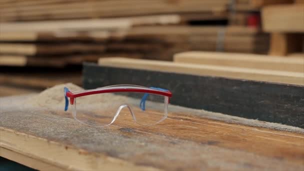 Γυαλιά κατασκευής γυαλιών. πριονίδι γύρω. Πριονιστήριο. Ιδέα συγκομιδής ξύλου. Αργή κίνηση. — Αρχείο Βίντεο
