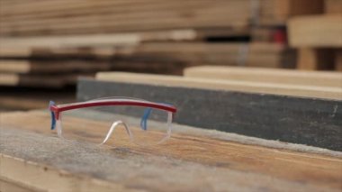 İnşaat gözlüğü. etrafında talaş. Kereste fabrikası. Odun hasadı konsepti. Yavaş çekim.