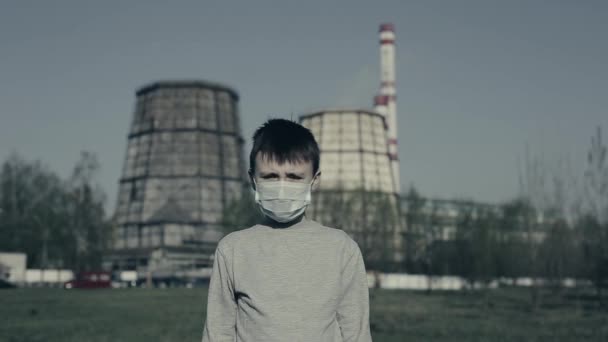 Genç çocuk öksürüyor ve Fabrika Bacalarına karşı kirlilik maskesi takıyor. Çocuk kirlilik yüzünden boğuluyor.. — Stok video