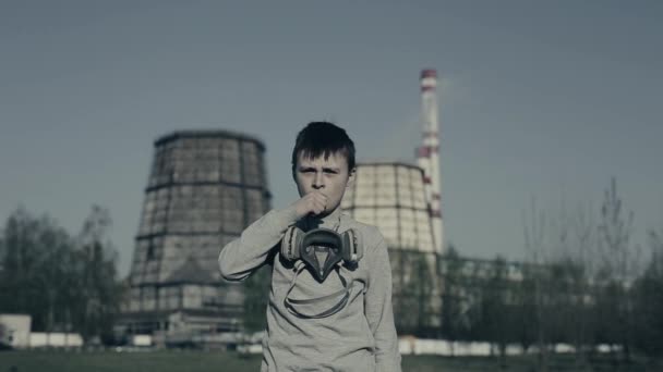 Młody boyis kaszel i noszenie maski zanieczyszczenia przed Factory kominy. Chłopiec dusi ze względu na zanieczyszczenie. — Wideo stockowe