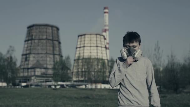 Jeune garçon portant un masque à gaz contre les cheminées d'usine. Le garçon étouffe à cause de la pollution. Guy tousse — Video