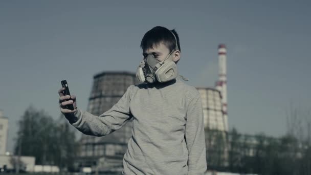 Fabrika Bacalarına Karşı cep telefonu kullanan solunum cihazı takan genç çocuk. Hava kirliliği kavramı. Çernobil — Stok video