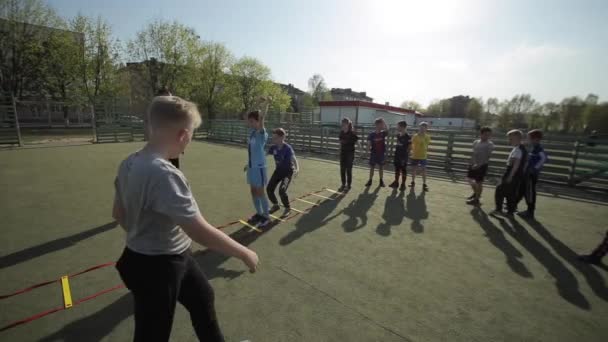 Bobruisk, Biélorussie - 15 juin 2019 : La jeune équipe de football s'échauffe avant le match. Les enfants faisant des exercices entraîneur de football entraîne les enfants . — Video