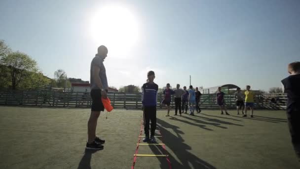 Bobruisk, Białoruś-15 czerwca 2019: młoda drużyna piłkarska Rozgrzewka przed grą. Dzieci wykonują ćwiczenia trener piłkarski trenuje dzieci. — Wideo stockowe