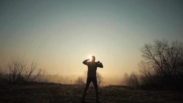 Silhueta de louco engraçado dançando contra o nascer do sol ou pôr do sol. bem sucedido homem alegre e alegre dançando no fundo do sol . — Vídeo de Stock