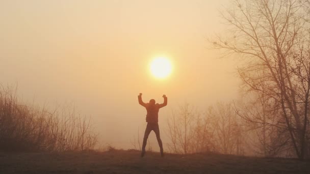 일출이나 일몰에 대해 춤을 재미 미친 남자의 실루엣. 태양의 배경에 춤 을 성공적으로 즐겁고 쾌활한 남자. — 비디오