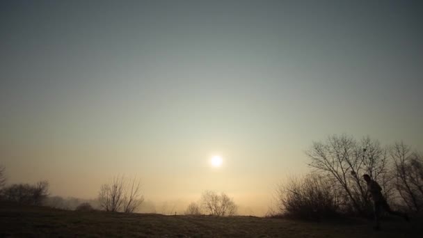 Silhouette eines Laufenden am Morgen gegen den Sonnenaufgang. — Stockvideo