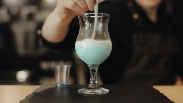 Ένας μπάρμαν που ανακατεύει γάλα σε ένα γυάλινο μπαρ με ένα κουτάλι. Μια κοντινή προβολή — Αρχείο Βίντεο