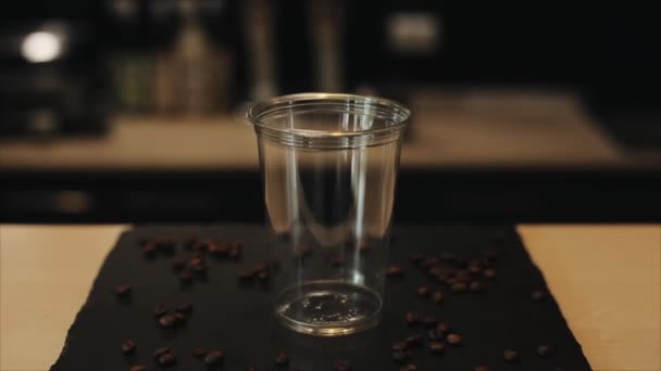 Zblízka na Barista ruku, která dává kostky ledu do plastikového kelímku — Stock video