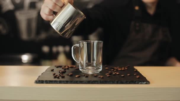 En närbild av Barista hälla varm choklad i en glas mugg — Stockvideo