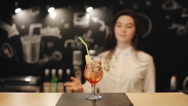 Молодая барменша пробует красное мохито у барной стойки — стоковое видео
