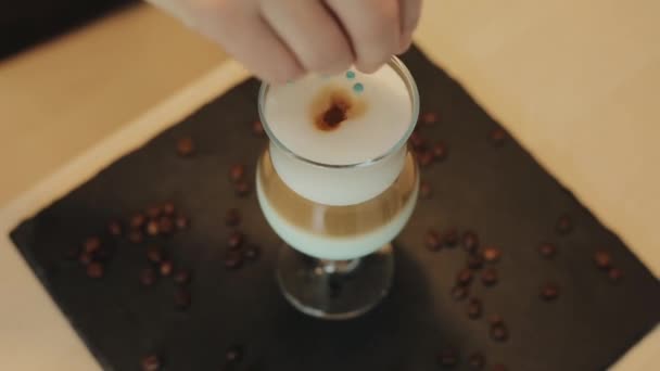 咖啡师手工装饰新鲜冲泡的咖啡。顶部视图。桌上的咖啡豆 — 图库视频影像
