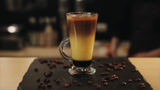 Het decoreren van een ijskoud koffie drankje met een sinaasappel schijfje. Een close-up — Stockvideo