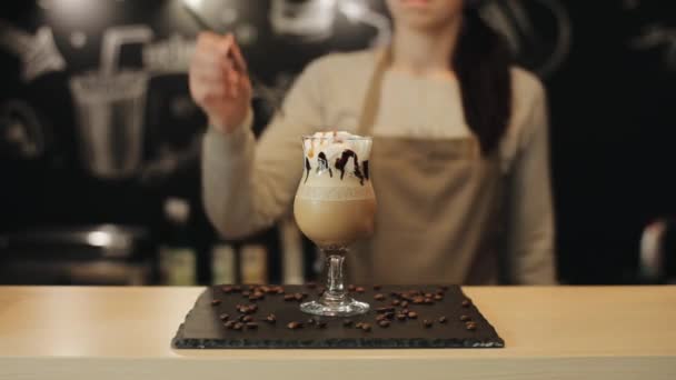女性咖啡师将一根黑色的稻草放入郁金香玻璃杯中，玻璃杯中装有咖啡饮料。特写 — 图库视频影像