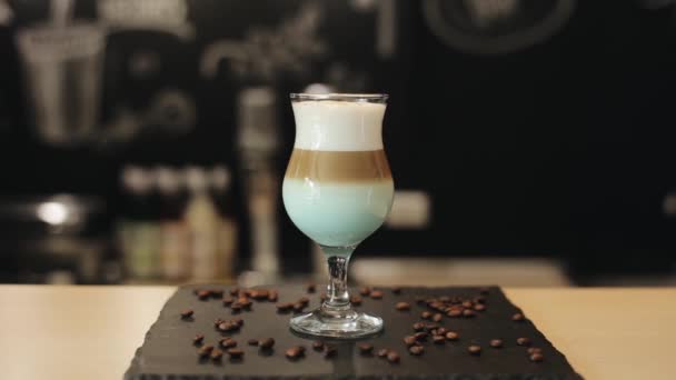A pôr uma palhinha numa chávena de café. Grãos de café no balcão do bar — Vídeo de Stock