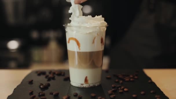 Schlagsahne auf einen Kaffee-Cocktail geben. Dekorieren mit Schoko-Popcorn und Karamell darüber gießen — Stockvideo