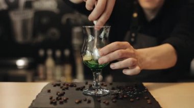 Mojito yapma süreci. Barman elleri metal bir kaşıkla bir bardak içinde kireç sıkmak