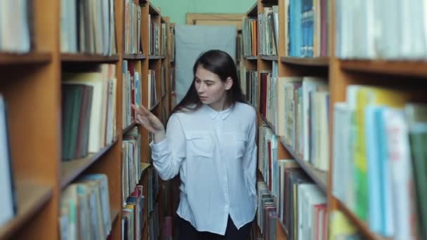 Bobruisk, Weißrussland - 11. April 2019: lustige verrückte Studentin mit Brille, die Spaß in der Bibliothek hat. Frau albert in der Bibliothek herum. — Stockvideo