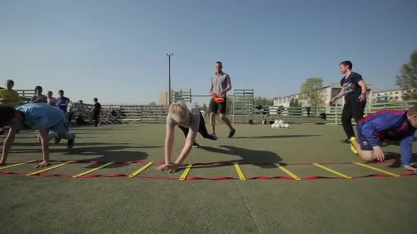 Bobruisk, Weißrussland - 15. Juni 2019: Junge Fußballmannschaft wärmt sich vor Spiel auf. Kinder machen Übungen Fußballtrainer trainiert Kinder. — Stockvideo