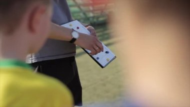 Genç Futbol antrenörü antrenör koçluk çocuklar taktik strateji manyetik beyaz tahta kullanarak. Futbol antrenörü çocuk futbol takımı maç taktikleri açıklayan.