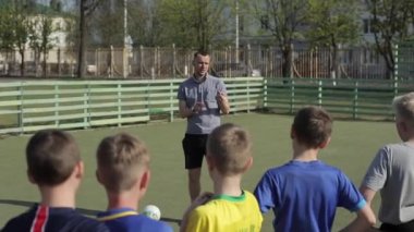 Genç Futbol antrenörü antrenör koçluk çocuklar taktik strateji kullanarak. Futbol antrenörü çocuk futbol takımı için maç taktikleri açıklayan. Koç ıslıkları