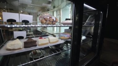 Buzdolabından çörekli bir tabak alan bir kadın el