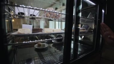 Buzdolabından çörekli bir tabak alan bir kadın el