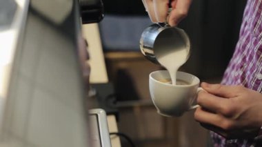 Erkek barmen ellerin yakından görünümü espresso latte yapma ile bir fincan içine buharda süt dökerek