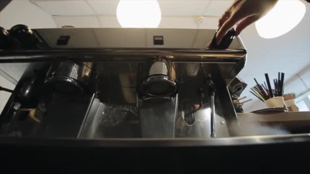 Una joven barista hermosa llega a una máquina de café profesional y hace que salga vapor de ella. Una vista cercana — Vídeo de stock
