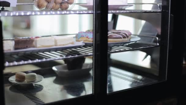 Uma mão masculina pegando um prato com donuts na geladeira — Vídeo de Stock