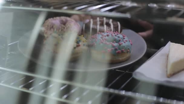 Ένα θηλυκό χέρι που παίρνει ένα πιάτο με ντόνατς στο ψυγείο — Αρχείο Βίντεο