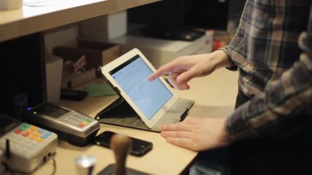 Una visione ravvicinata delle mani maschili utilizzando un tablet digitale. Dietro un bancone da bar — Video Stock