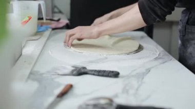 Taze hamur pizza tabanı hazırlayan erkek şefin yakın çekim