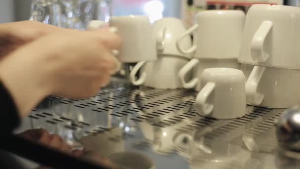 Un primo piano di mani femminili mettendo due tazze di caffè pulite capovolte sopra una caffettiera dove altre tazze pulite sono sdraiate — Video Stock