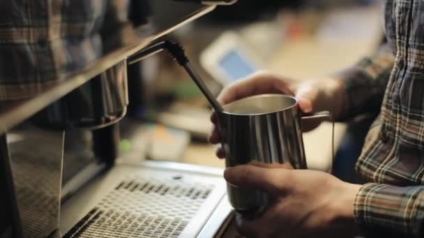 En närbild av manliga Barista hand gör ångad mjölk med hjälp av en kaffebryggare — Stockvideo