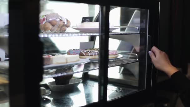 Una mano femenina tomando un plato con rosquillas de la nevera — Vídeo de stock