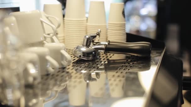 Czyste kubki ceramiczne i papierowe, dwa uchwyty do kawy leżące do góry nogami na górze ekspresu do kawy. Widok z bliska — Wideo stockowe