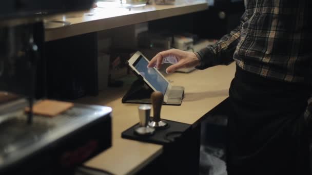 Manliga Cashier händer använder en mobil digital tablett bakom en kafé-disk. En närbild — Stockvideo