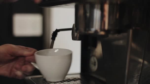 Gießen Sie kochendes Wasser aus einer professionellen Kaffeemaschine in eine Tasse mit Tee. Nahaufnahme — Stockvideo