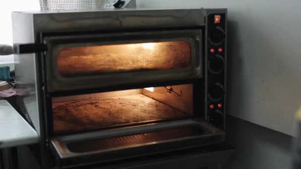 Colocar uma base de pizza de massa em um forno elétrico — Vídeo de Stock