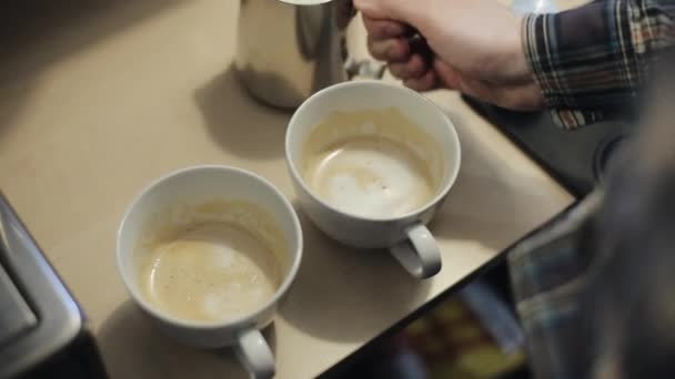 Proces tvorby dvou šálků latte. Zblízka — Stock video