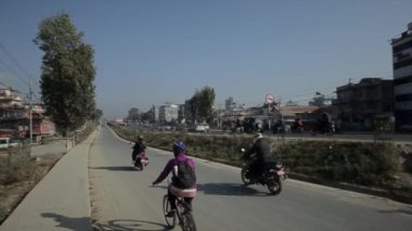 Güneşli bir yaz gününde Nepalli Hint şehrinin yolunda hareketli bir trafik var. Bir Asya şehrinin günlük hayatı