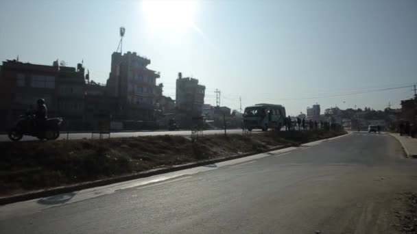 Una vista di una fermata dell'autobus su una strada trafficata accanto a grattacieli a Kathmandu in una luminosa giornata di sole. Nepal. Vita quotidiana della città — Video Stock