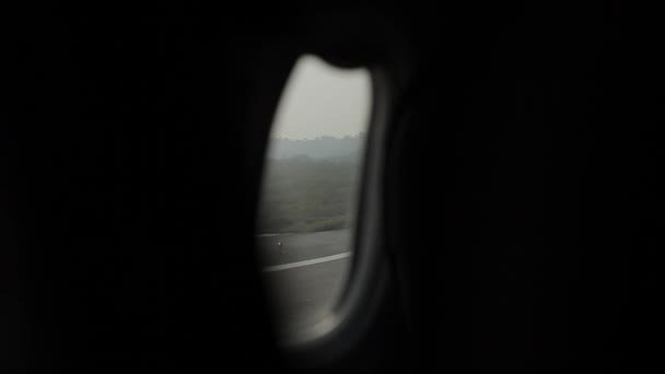 一排排不同颜色和尺寸的飞机站在一个巨大的沥青路面平台上，背靠着树木。机场。从飞机的窗户开枪射击 — 图库视频影像