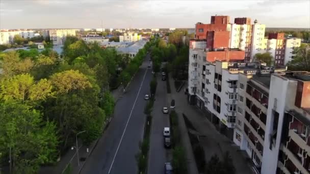 Eine Luftaufnahme der Stadtstraße zwischen den Bäumen im Zentrum der Stadt und den angrenzenden Industriegebieten und der Kirche. Schnelle Schussgeschwindigkeit — Stockvideo