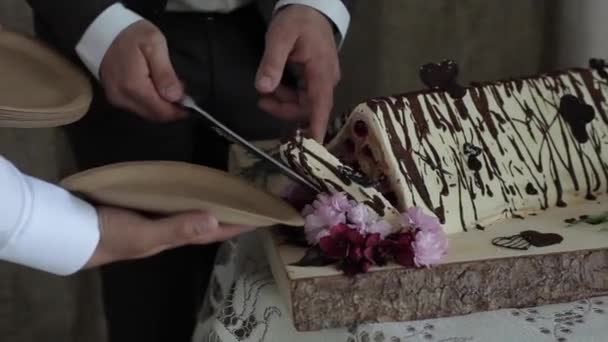 Close-up dari asli segitiga kue pernikahan. Pengantin perempuan dan laki-laki memotong kue menjadi potongan-potongan bersama untuk tamu mereka. Tradisi pernikahan — Stok Video
